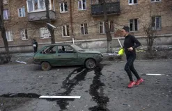 A woman exercises near a car 