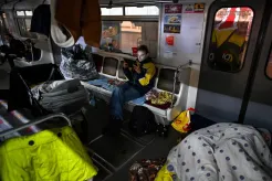 A boy uses a tablet sitting in a metro car